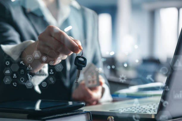 real estate agent shows a real estate key . real estate agent shows a real estate key against a blurred office background. turnkey project stock pictures, royalty-free photos & images