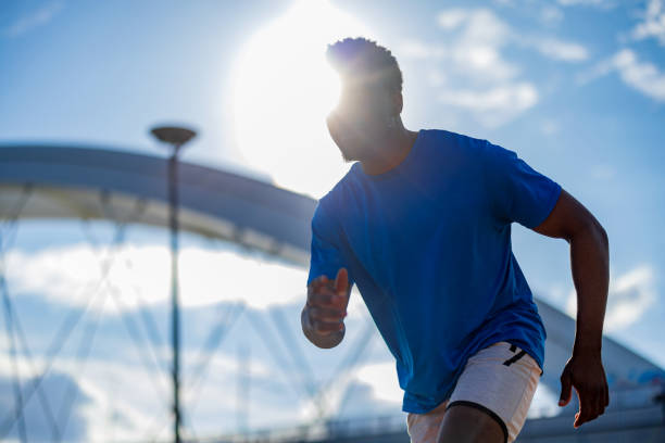 A young African American man races towards a healthier tomorrow with each outdoor run, his commitment to wellness echoing with each step on the pavement, a moving inspiration for a life lived actively and with purpose