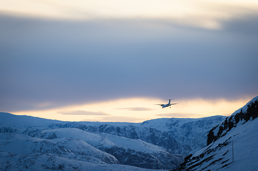 Arctic landscape with landing plane on airport.