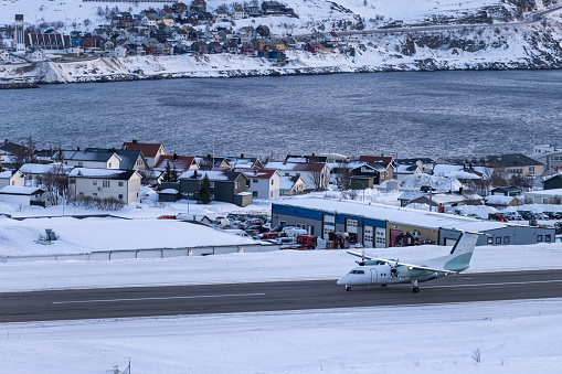 Arctic landscape with landing plane on airport.