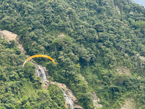 Person paragliding over waterfall