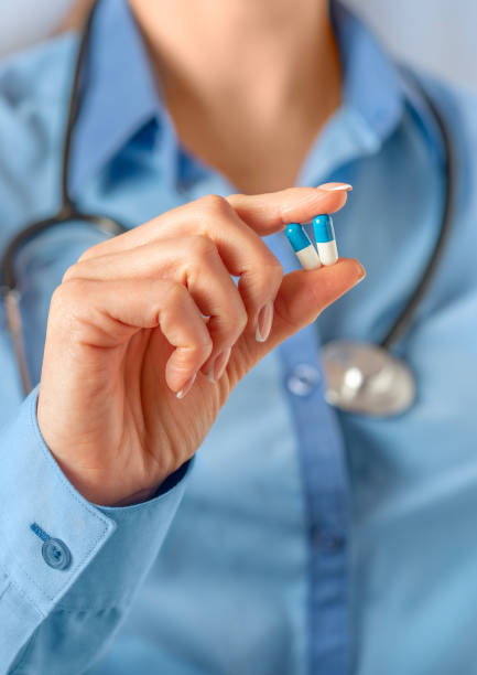 istock Female doctor holding two capsules in hand, selective focus. 2048736311