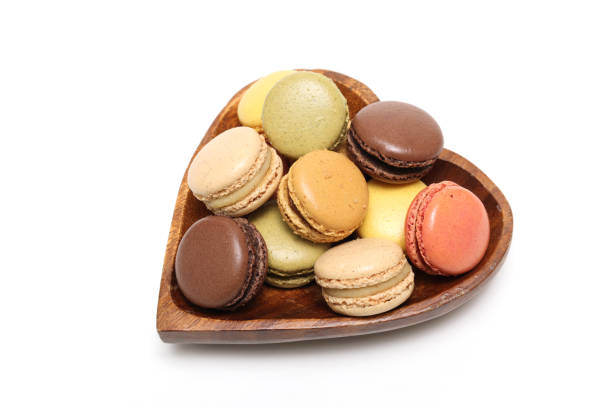 istock Various colored macaroons in a heart shaped wooden bowl isolated on a white background. 2048736834