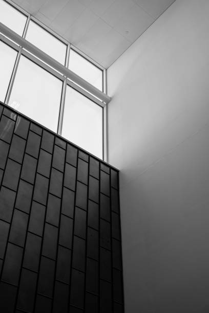 istock Looking up tall dark wall with a window near the white roof. 2048741038