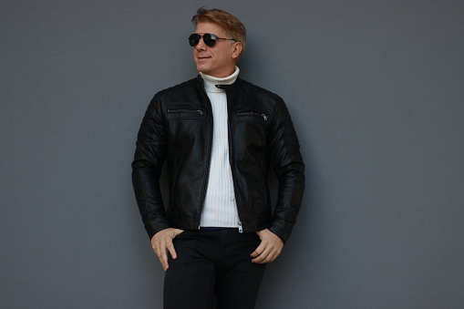 posing wall grey sunglasses leather jacket positive emotion casual