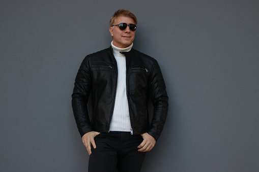 posing wall grey sunglasses leather jacket positive emotion casual