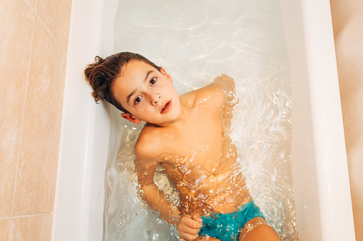 Above shot of a boy having fun diving in a bathtub full with clean water