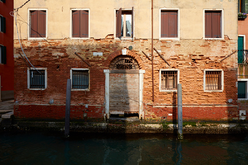 An old building facade on a canal in Venice