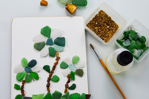 Sea glass is small polished pieces of broken bottles and other glass products collected on the beach and pieces of amber. A gift for a holiday on March 8, birthday, mother's day