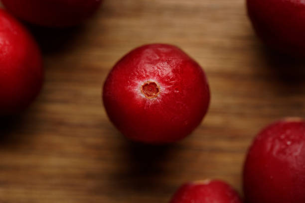 A top view of cranberries arranged on a rustic wooden board