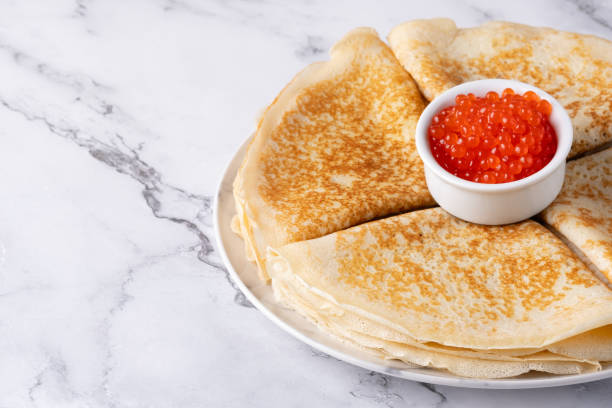 istock Pancakes with red caviar on a marble table, with copy space for text 2048885030