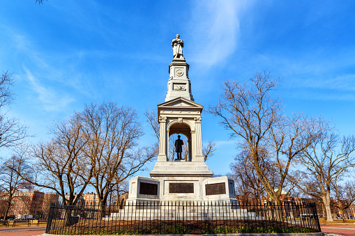 Cambridge, Massachusetts, USA - February 27, 2024: On Cambridge Common is a memorial to the American Civil War with a statue of Abraham Lincoln in a covered area near the base of the memorial. On top of the memorial is a statue of a soldier. Cambridge Common is a public park and National Historic Landmark. It is located near Harvard Square and borders on several parts of Harvard University.