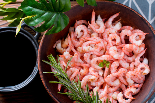 Boiled peeled shrimp with soy sauce on a plate. Dietary seafood