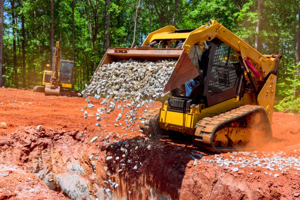 istock Unloading gravel with an excavator bucket skid steer loader during a construction project 2048958962