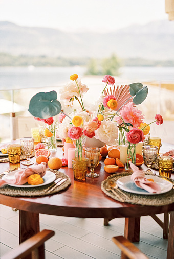 Plates with knotted napkins stand on mats on a table with a colorful bouquet. High quality photo