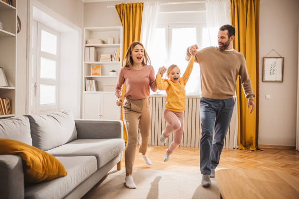 Happy day Happy family, mother, father and daughter jumping and playing at home. dancing dad stock pictures, royalty-free photos & images