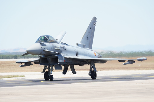 Eurofighter Typhoon fighter plane of the Spanish Air Force performing training maneuvers during a sunny day with blue sky in Andalusia, Spain. Concept: defense, war, army, air force.