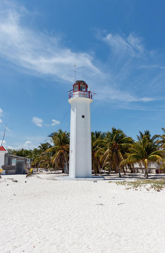 White lightouse with lush palm trees at remote beach cabo catoche in holbox mexico