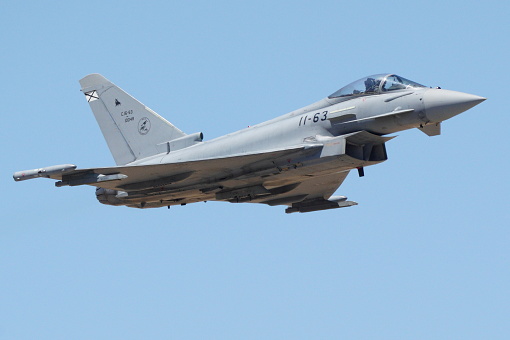 Eurofighter Typhoon fighter plane of the Spanish Air Force performing training maneuvers during a sunny day with blue sky in Andalusia, Spain. Concept: defense, war, army, air force.