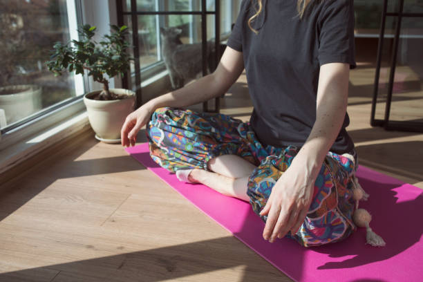 istock Young woman exercising and meditating at home 2049078024