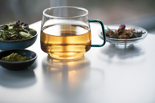 Close-up of cup tea and herbs, dry teas.