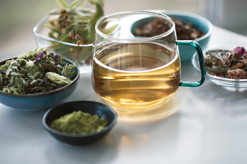 Close-up of cup tea and herbs, dry teas.