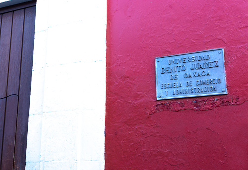 Oaxaca, Mexico: A plaque on the red wall of the Universidad Benito Juarez de Oaxaca in downtown Oaxaca, founded in 1827.