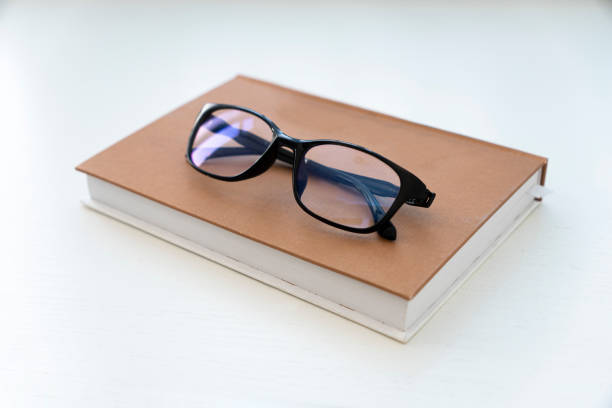 istock Reading glasses with books on white table 2049118444