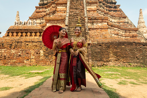 Young Asian women in traditional Thai clothes against the ruins of Ayutthaya, the ancient capital of the kingdom of Siam. Ayutthaya, Thailand May 30, 2023