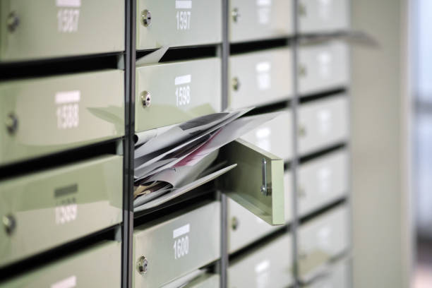 skrzynki pocztowe w kondominium są zaśmiecone korespondencją, przepełnione. papierowe listy leżą w otwartej skrzynce pocztowej, wypełnionej spamem. - mailbox mail junk mail opening zdjęcia i obrazy z banku zdjęć