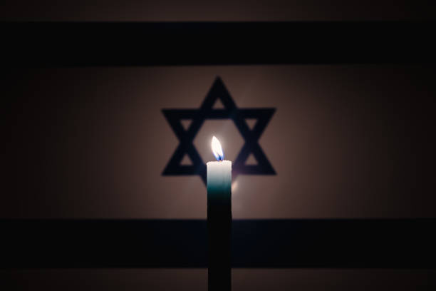 istock Burning candle on Israel flag background. 2049127024