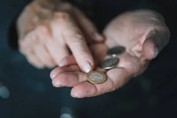 Defocused view to elderly woman counts metal coins, wrinkled female hands close up. Concept of poverty, pension payments, retiree with money. poverty pensioners. old women's hands count coins.