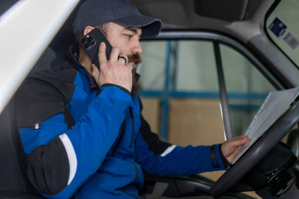 istock A delivery man uses a mobile phone while sitting in a delivery van 2049130838