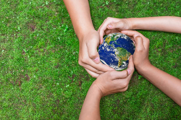 istock Environment conservation concept. Young children hands holding globe on green nature background for sustainable development goal.  world image by NASA 2049134736