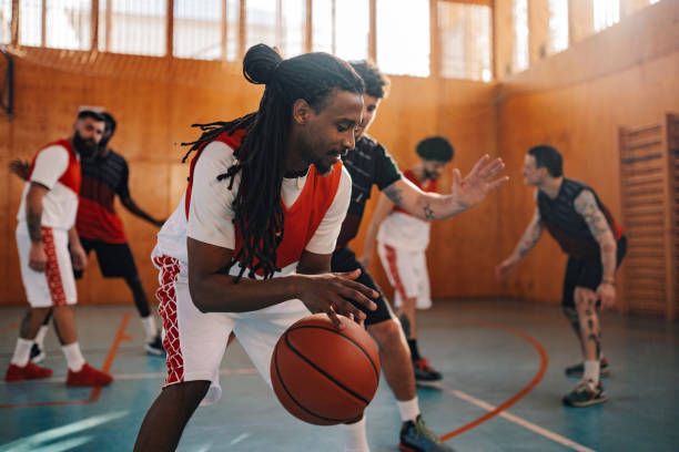 istock Interracial basketball player dribbling a ball on training with teammates. 2049135894