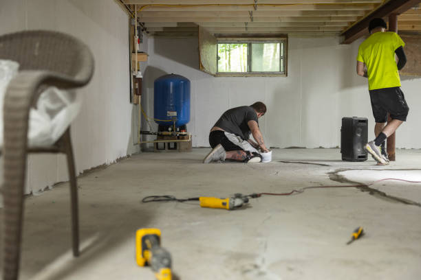 istock Two workers waterproofing basement floor with hydraulic cement. 2049153520