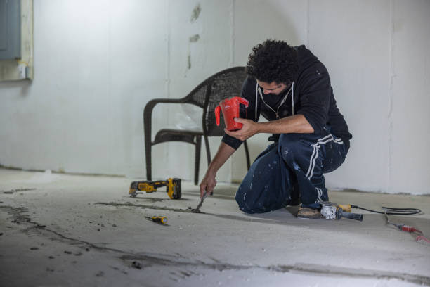 istock Worker using hydraulic cement to waterproof the cracks in the basement floor. 2049153522