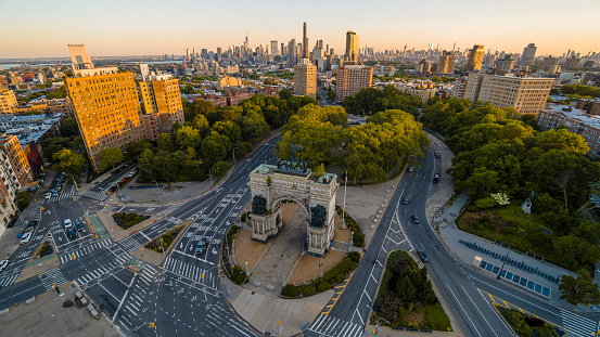 Grand Army Plaza with historic Soldiers and Sailors Memorial Arch in Brooklyn, New York, at sunrise in spring. Panoramic view with Manhattan at the backdrop.