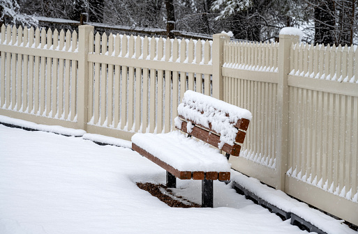 Chair and fence covered with snow