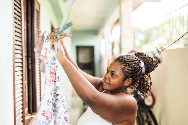 African woman putting clothes on clothesline