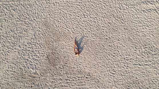 Aerial view of woman laying on a white Caribbean beach