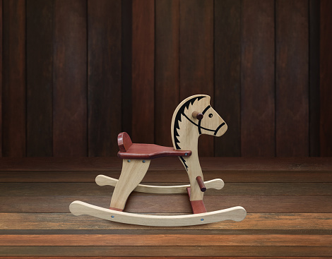Wooden rocking horse isolated on wooden background