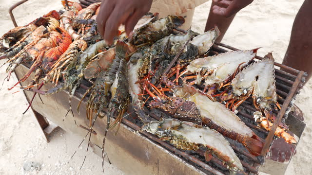 Local man catches lobsters and prawns cooked on the beach with his hand
