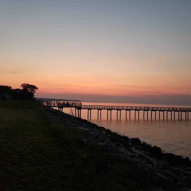 istock Long pier over the ocean under orange sunset 2049289494