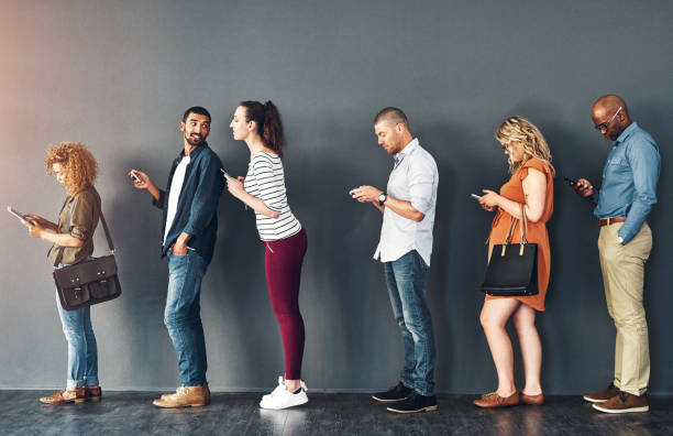 istock Studio shot of people waiting in line against a grey background 2049406951