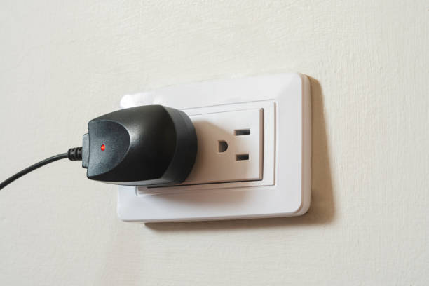 istock Black digital device charger connected to white outlet, recharging and energy theme, horizontal photography 2049408500