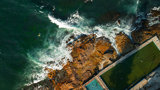 Stunning ocean view of the waves and rock pool in the Northern Beaches of NSW, Sydney, Australia. The view was captured from above using a drone. Dee Why
