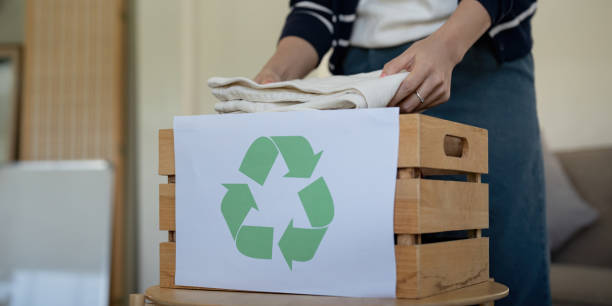 istock Woman pack box with used clothes for reuse. Reusing, recycling material and reducing waste in fashion, second hand apparel idea. Circular fashion, zero waste concept 2049449999