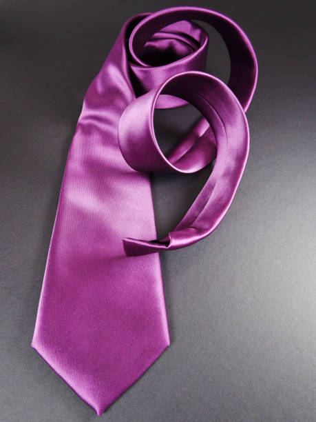 istock A purple color polyester fabric necktie rolling with dark background 2049496060