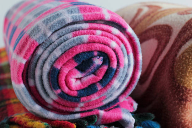 Various colorful fabric pieces, threads, lace, and buttons arranged for patchwork crafting and creative textile recycling on a wooden surface.